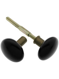 Pair of Black Porcelain Doorknobs for Rim Locks with Brass Shanks in Antique Brass.